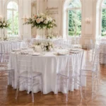 Transparente Chiavari-Stühle an festlich dekorierten Hochzeitstischen