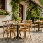 Hellbraune Crossback-Stühle an gedeckten Tischen auf einer überdachten Terrasse